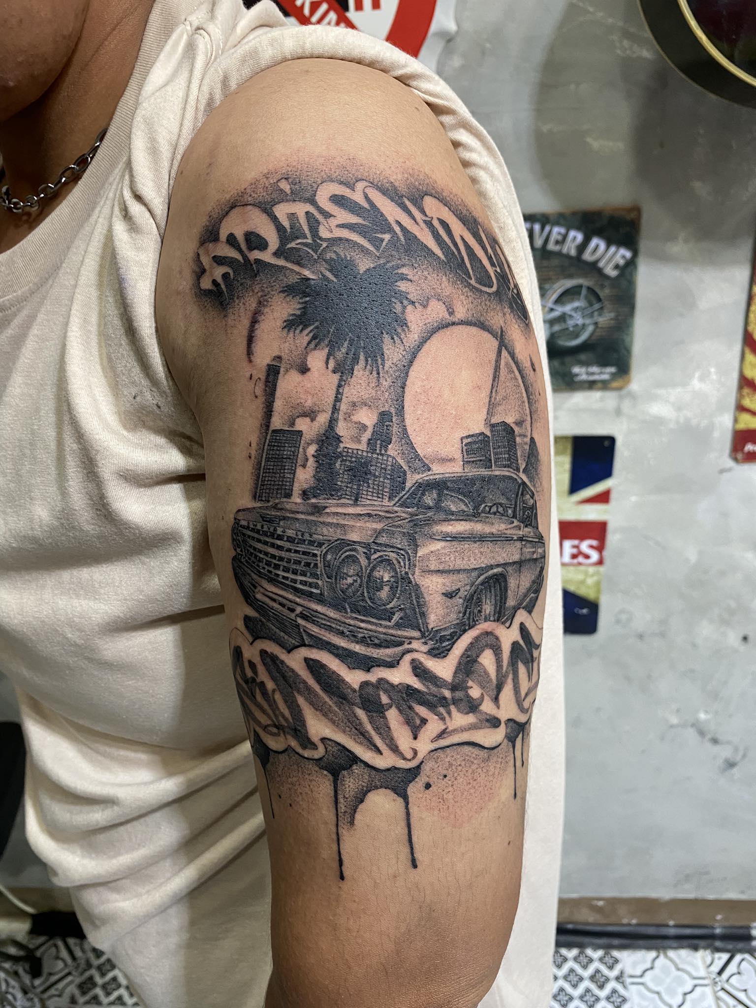 Cadillac, City Scape, Shoulder, Cool, Black and Grey Tattoo by Max. He is a highly skilled tattoo artist at Lethal Ink Tattoo in Pattaya. He is celebrated for is expertise in black and grey, anime, manga, Thai art, and tribal motifs. Max, Cadillac, City Scape, Shoulder, Cool, Black and Grey Tattoo, Lethal Ink, Pattaya, 2024