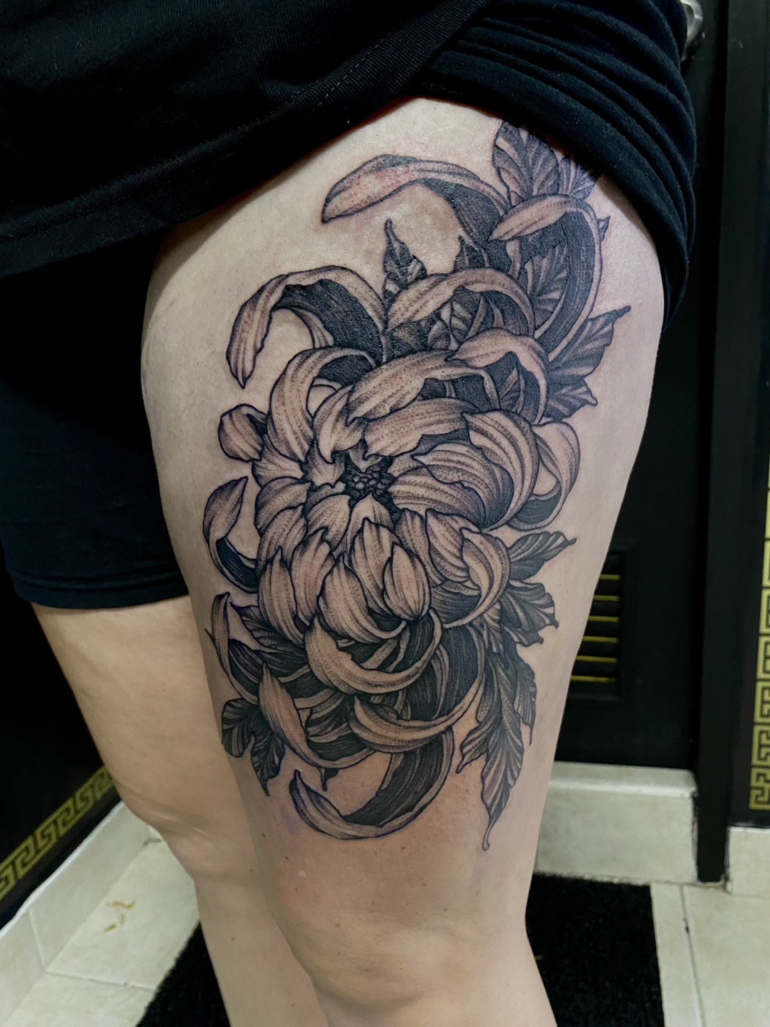 Black and gray, Flower, Thigh tattoo by Max. He is a highly skilled tattoo artist at Lethal Ink Tattoo in Pattaya. He is celebrated for is expertise in black and grey, anime, manga, Thai art, and tribal motifs. Black and gray, Flower, Thigh Tattoo, Max, Lethal Ink, Pattaya, 2024