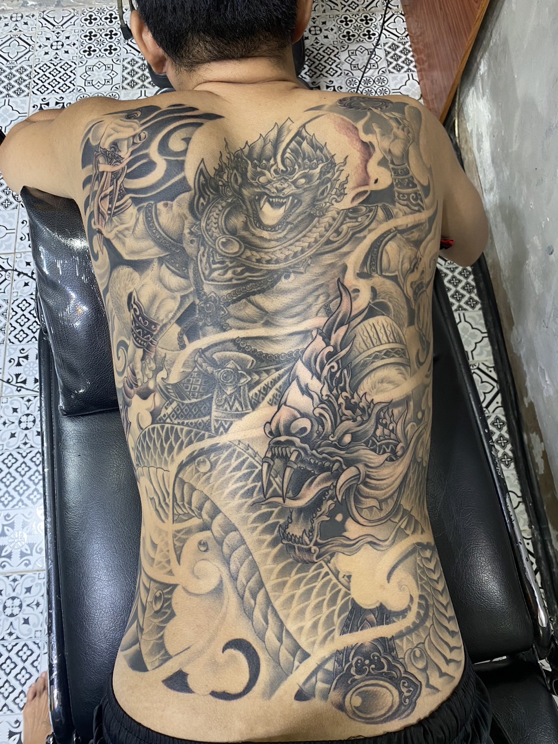 Black, Dragon, God, back tattoo by Max. He is a highly skilled tattoo artist at Lethal Ink Tattoo in Pattaya. He is celebrated for is expertise in black and grey, anime, manga, Thai art, and tribal motifs. Black, Dragon, God, back Tattoo, Max, Lethal Ink, Pattaya, 2024