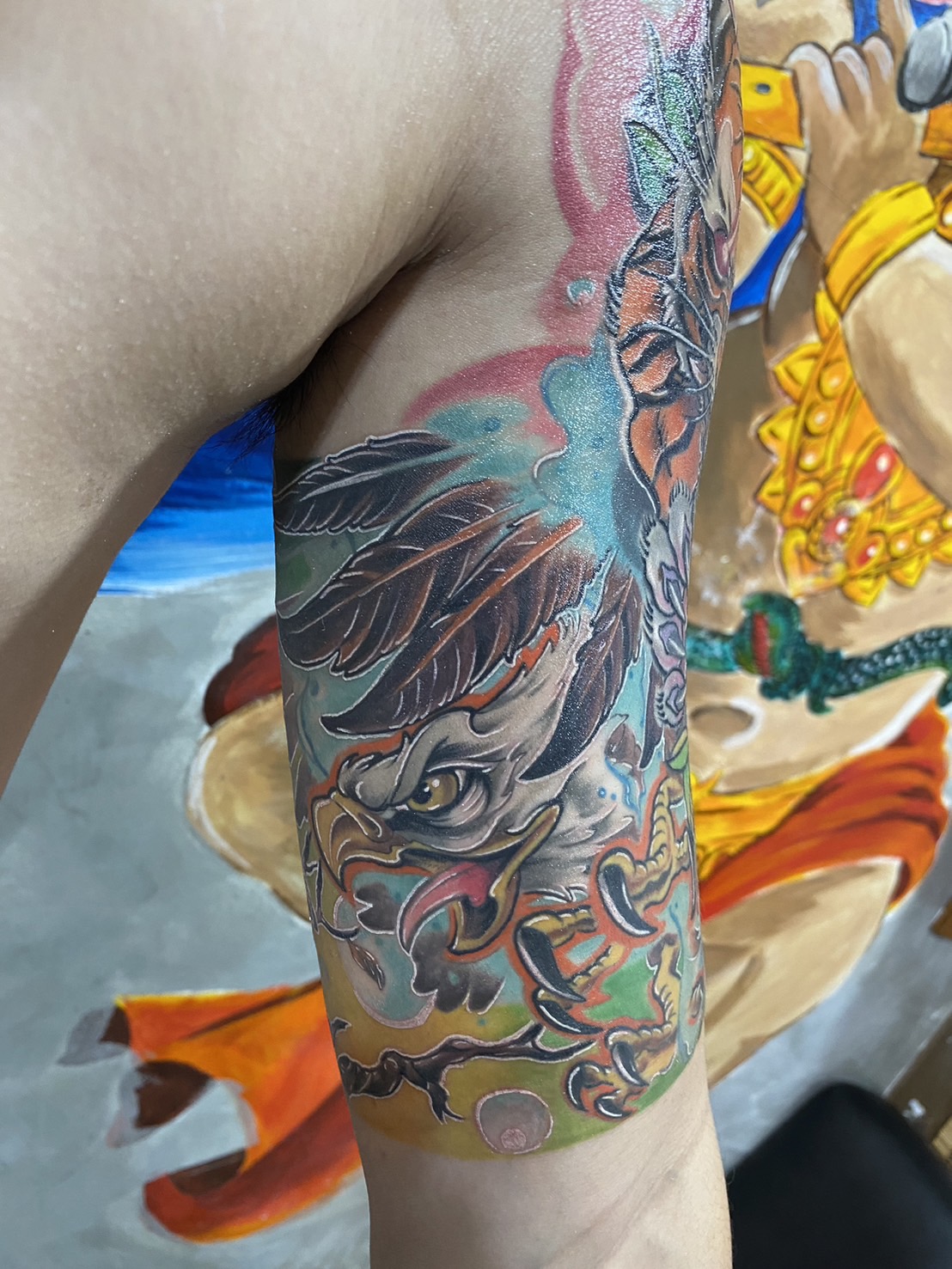 Eagle, Color, Animated, Tricep tattoo by Max. He is a highly skilled tattoo artist at Lethal Ink Tattoo in Pattaya. He is celebrated for is expertise in black and grey, anime, manga, Thai art, and tribal motifs. Eagle, Color, Animated, Tricep Tattoo, Max, Lethal Ink, Pattaya, 2024
