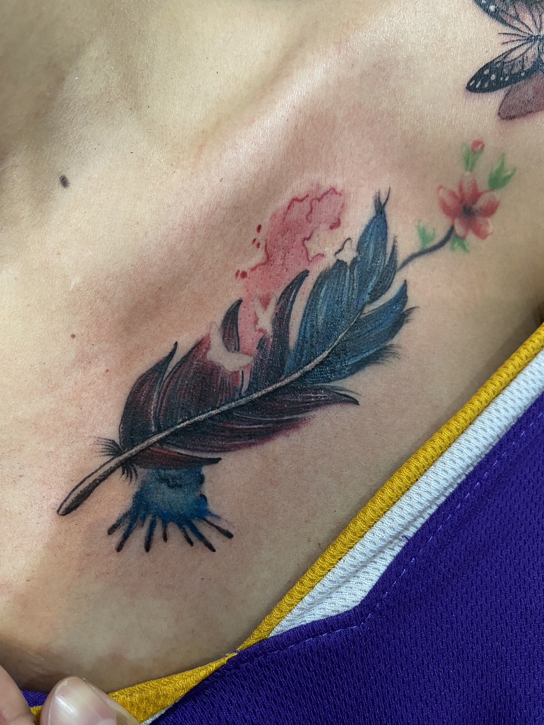 Feather, Flowers, Color, Chest tattoo by Max. He is a highly skilled tattoo artist at Lethal Ink Tattoo in Pattaya. He is celebrated for is expertise in black and grey, anime, manga, Thai art, and tribal motifs. Feather, Flowers, Color, Chest Tattoo, Max, Lethal Ink, Pattaya, 2024