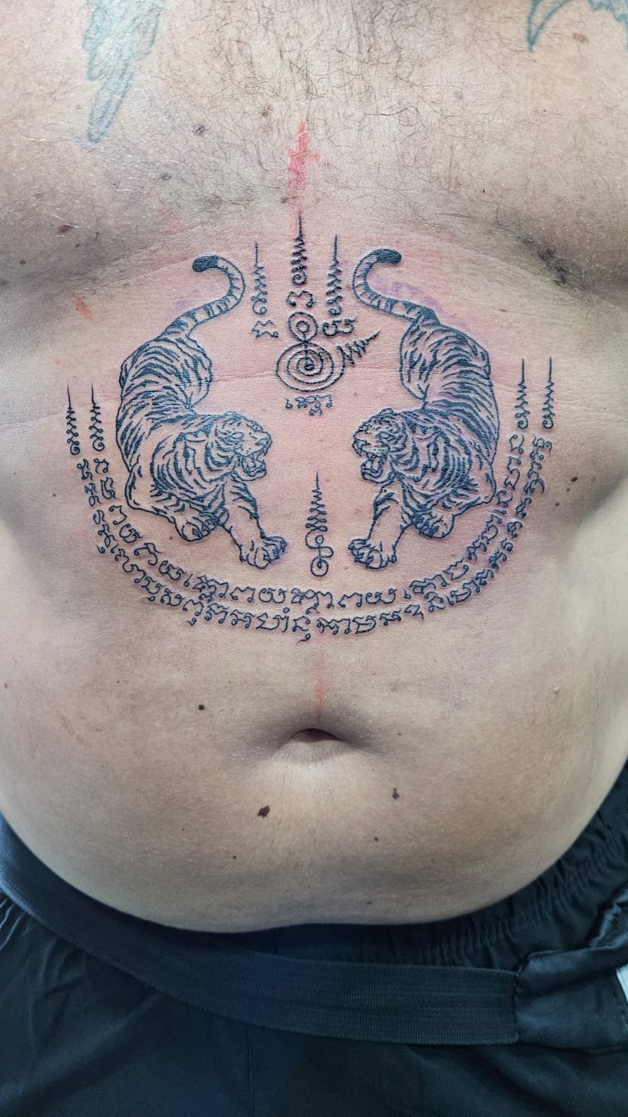 Sak Yant, Thai Traditional, Black, Stomach Tattoo by Toon. He is a highly skilled tattoo artist at Lethal Ink Tattoo in Pattaya. He is celebrated for his expertise in Japanese, Chicano, Realistic, New School, Old School, Neo Thai, and Bamboo Tattooing. Sak Yant, Thai Traditional, Black, Stomach Tattoo, Toon, Lethal Ink, Pattaya, 2024