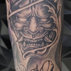 Black and grey Japanese Hannya tattoo with flowers by Apple at Lethal Ink Tattoo, Pattaya. Apple specializes in Japanese, Black & Grey, Fine Line, Ornamental, Minimal, and Script styles. Black and grey Japanese Hannya mask tattoo with flowers by Apple, tattoo artist at Lethal Ink Tattoo, Pattaya (2025)