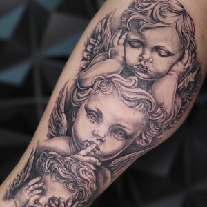 Realistic black and grey cherub angels tattoo by Sandy at Lethal Ink Tattoo, Pattaya. Sandy specializes in Realism, Black & Grey, Portrait, Illustrative, and Neo Traditional styles. Realistic black and grey cherub angels tattoo by Sandy, tattoo artist at Lethal Ink Tattoo, Pattaya (2025)