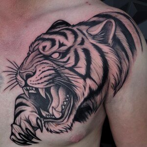 Black illustrative tiger head tattoo on chest by Sandy at Lethal Ink Tattoo, Pattaya. Sandy specializes in Illustrative, Blackwork, Realism, Neo Traditional, and Black & Grey styles. Black illustrative tiger head tattoo on chest by Sandy, tattoo artist at Lethal Ink Tattoo, Pattaya (2025)