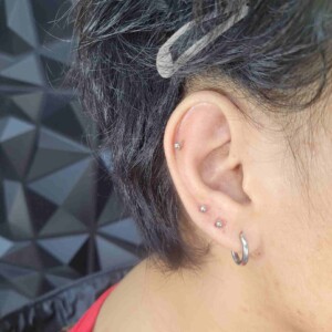 Perforación de lóbulo de la oreja con tres anillos y pendientes de acero quirúrgico en Lethal Ink Tattoo Pattaya. Piercing de tres anillos en el lóbulo de la oreja con pendientes de acero quirúrgico en Lethal Ink Tattoo Pattaya (2026)